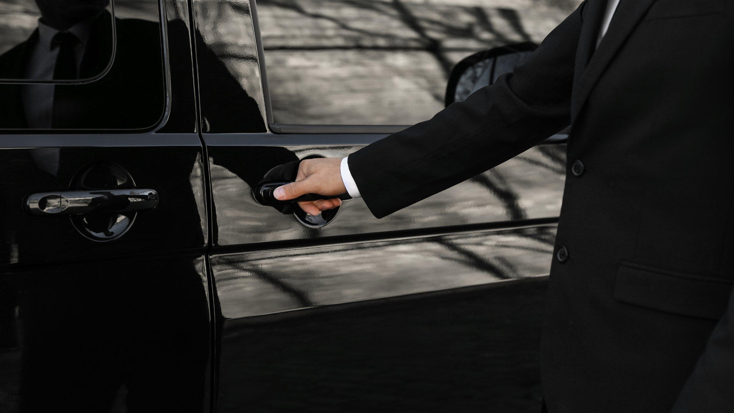 Professional chauffeur opening the door of a black luxury SUV in Chicago