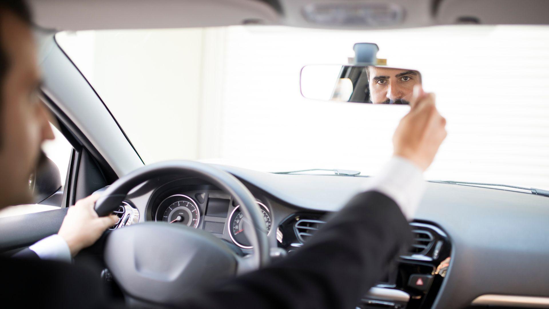 Chauffeur checking the rearview mirror before departure